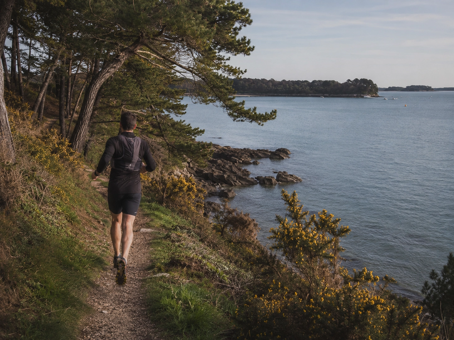 Traileur sur un sentier côtier du Golfe du Morbihan pendant une course nature